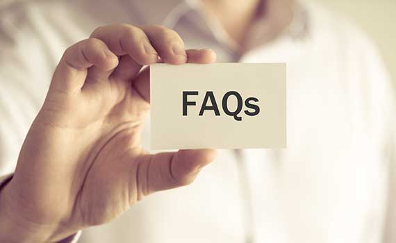 Person holding a white card with ‘FAQs’ text